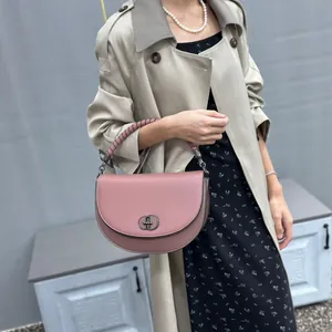 Elegant pink saddle handbag with vintage metal lock and top handle strap