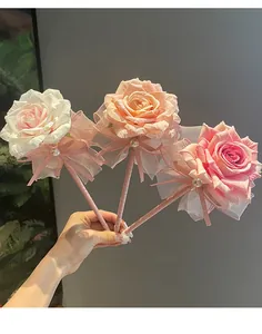 Detail view of artificial rose flower ballpoint pens with pearl and ribbon accents