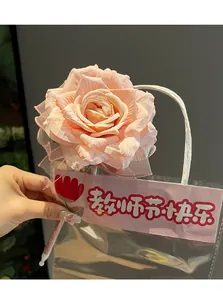 Close-up of a realistic pink artificial rose flower ballpoint pen in transparent gift bag