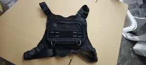 Detailed view of a black multi-functional tactical chest bag with adjustable straps.
