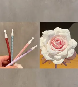 Nahaufnahme eines eleganten rosafarbenen künstlichen Rosen-Kugelschreibers mit bunten Stielen.