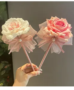 Detailed view of handmade decorative rose ballpoint pens with silk ribbons and pearl accents