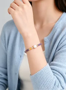 Detail shot of a natural amethyst bamboo-style beaded bracelet with a freshwater pearl.