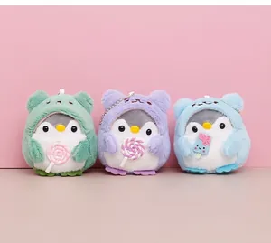 Detail view of three cute plush penguin keychains wearing colorful animal hoods and costumes