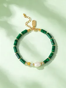 Detail of green malachite style bamboo bead bracelet with freshwater pearl and butterfly charm