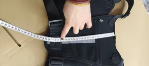 Macro view of black tactical vest chest bag being measured with a professional white tape