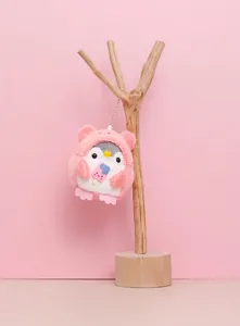 Detailed macro view of a cute plush penguin keychain with a pink hooded outfit pendant.
