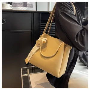 Elegant cream large capacity bucket bag with fashion strap detail shown on model