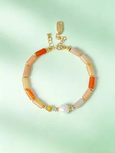 Close-up of elegant handmade beaded bracelet with bamboo-shaped jade and a large pearl