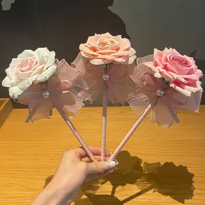 Hand-held set of three elegant artificial rose ballpoint pens in soft pink tones.