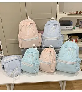 Detail showing variety of pastel school backpacks with lace and pearl bow decorations