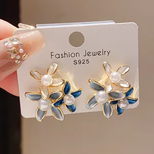 Detailed view of vintage flower earrings with blue enamel and pearls