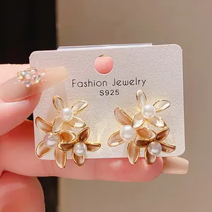 Detailed macro view of 18K gold-plated flower earrings with pearls and S925 silver needles.