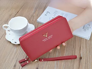 Close-up of a red double-zipper long wallet for women with elegant golden deer logo.