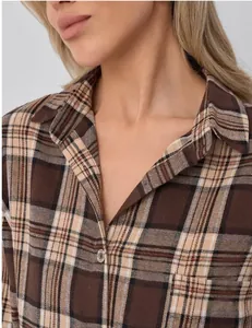 Detailed close-up of a women's brown and beige retro plaid shirt collar and pocket