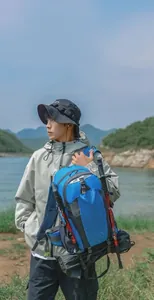 Model trägt einen blauen 40L wasserfesten Wanderrucksack in malerischer Landschaft