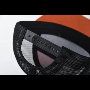Primo piano della chiusura snapback regolabile e del pannello a rete di un cappellino.