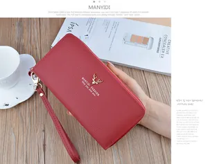 Detail shot of red leather long wallet with double zippers and gold deer head logo