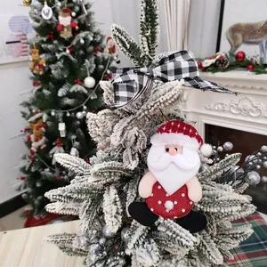 Handcrafted plush Santa Claus ornament hanging on a snowy Christmas tree branch