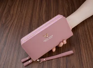 Primo piano di un portafoglio lungo rosa da donna in finta pelle con doppia cerniera