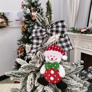 Detailed view of a cute snowman plush Christmas tree ornament with a black and white bow