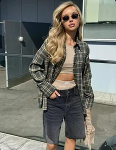 Model wearing American retro plaid shirt with crop top and denim shorts outdoors