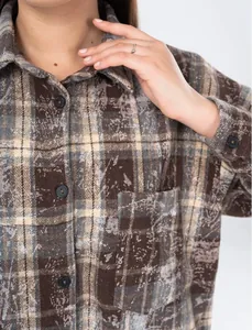 Detail view of the brown vintage plaid flannel shirt showing chest pocket and buttons