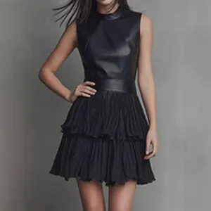 Detail view of a black sleeveless mock neck dress with a layered pleated skirt