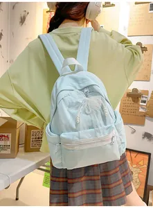 Stylish light blue student school bag featuring a cute lace bow and pearl chain decor