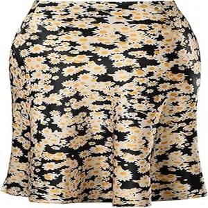 Detail of satin fishtail midi skirt with vibrant daisy floral print on black background.
