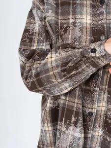 Detailed macro shot of vintage brown plaid flannel shirt featuring unique distressed pattern