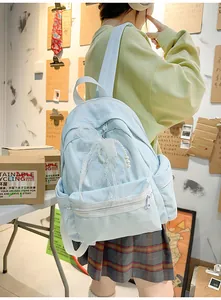 Light blue school backpack for students featuring a decorative lace bow and pearls