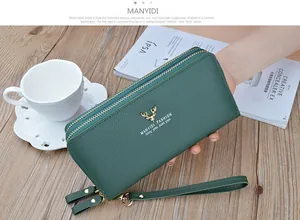 Detail of green pebbled leather women's wallet with double gold zippers and wristlet.