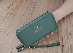 Dettaglio del portafoglio verde in pelle martellata con doppia cerniera dorata da donna.