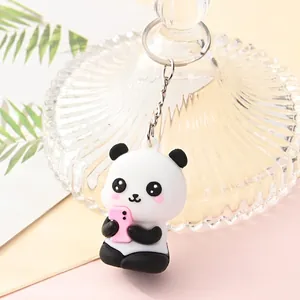 Close-up of a cute cartoon panda keychain holding a pink phone charm