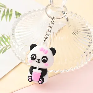 Detailed view of a cute cartoon panda keychain with pink bow and cup accessory.
