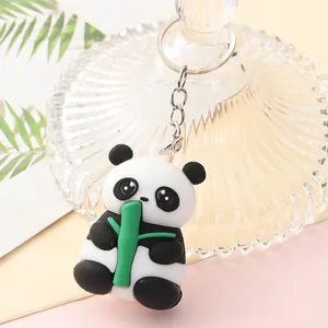 Detailed close-up of a cute cartoon panda keychain holding a green bamboo stalk