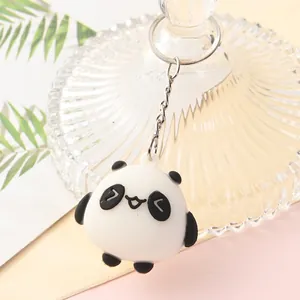 Detailed close-up of a cute cartoon panda keychain with round black and white body