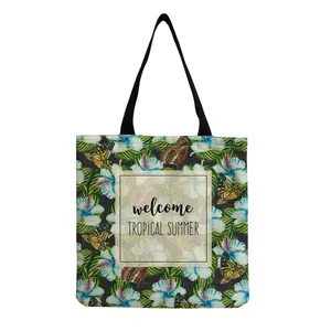 Close-up detail of tropical leaf print tote bag with welcome TROPICAL SUMMER text