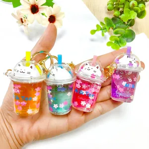 Close-up of four cute sakura cat milk tea cup keychains with colorful liquid oil inside
