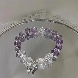 Detailed view of lavender purple beaded bracelet with a silver butterfly charm