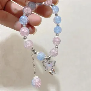 Close-up of a beaded butterfly bracelet with pink and blue gradient cracked beads