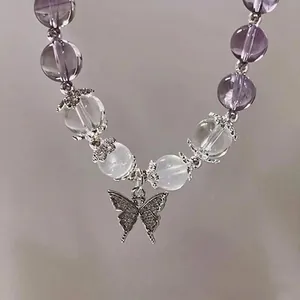 Close-up of purple lavender beaded bracelet with a silver butterfly pendant.