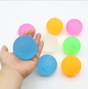 Hand holding a blue maltose squishy ball among a colorful set of stress relief toys