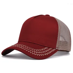 Close-up detail of a retro burgundy trucker hat featuring mesh back and zigzag brim stitching.
