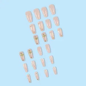 Nude pink press-on nails set featuring gold butterfly charms and rhinestones detailing
