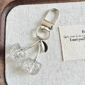 Detailed macro view of the sparkling clear cherry keychain with silver glitter accents