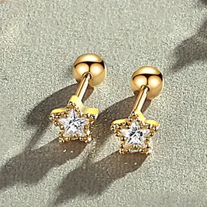 Close-up of gold star-shaped screw back earrings with crystal inlay
