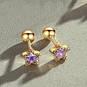 Close-up of gold screw-back stud earrings featuring purple star crystals on stone surface.