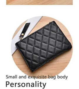 Close-up of black quilted coin purse with zipper and elegant diamond stitching
